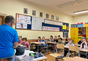 Prowadzący pokazuje czym kolejno będą zajmowali się uczniowie.