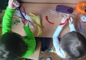 Leon i Hanna, siedząc w szkolnej ławce, konstruują swoje wagi.