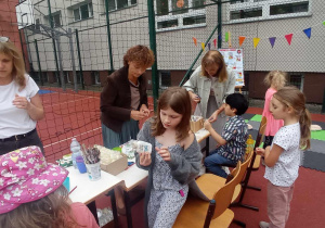 Pani Iwona i Pani Kasia przygotowały stoisko z pomalowanymi na biało buteleczkami, które uczniowie mogli przyozdobić techniką decoupage.