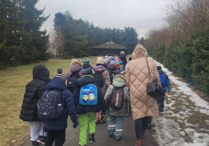 Uczniowie idą chodnikiem do Ośrodka Edukacji Technicznej "Pinokio".