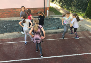 Grupa uczennic wykonuje kolejny taniec dowolny na boisku szkolnym.