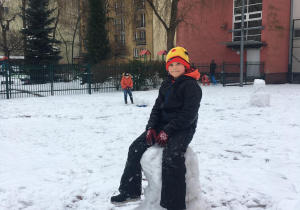 Stasio siedzi na swojej śnieżnej budowli.