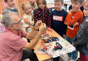Pan Jacek cierpliwie tłumaczy i jednocześnie pokazuje dzieciom, jak tworzyć biżuterię i drzewka szczęścia.