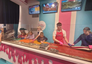 Lena, Nina, Kacper i Kasia z pomocą prowadzących wyrabiają słodką masę na swoje lizaki.