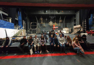Uczniowie siedzą na scenie Teatru Wielkiego.