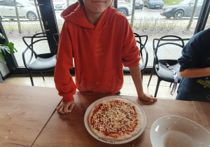Leon prezentuje gotową do pieczenia pizzę.