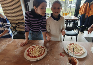 Lidzia i Jagoda pokazują swoje pizze.