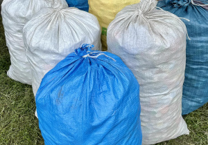 Prawie 100 kilogramów plastikowych nakrętek znajduje się w dziesięciu workach.