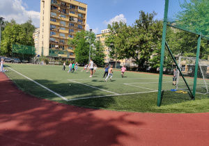 Uczniowie rozgrywają mecz na boisku.