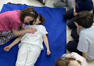 Dziewczynka ćwiczy sprawdzanie czynności oddechowych u "osoby poszkodowanej".