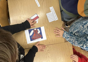 Uczniowie rozwiązują zadanie w klasie.