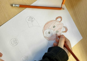 Dziewczynka koloruje misia.