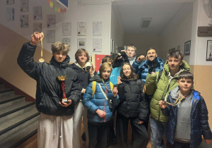 Grupowe zdjęcie naszej zwycięskiej drużyny. Uczniwoie prezentują puchar i medale.