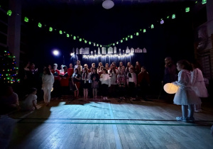 Chór śpiewa piosenkę, na scenę wchodzą śnieżynki.