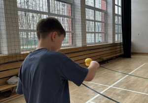 Chłopiec utrzymujący jajko na łyżce pokonuje wyznaczoną trasę.