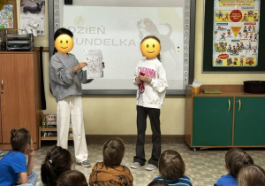 Na początku spotkania starsze koleżanki, stojąc na tle slajdu z prezentacji, wyjaśniły co znajduje się na plakacie "Dzień Kundelka", który przygotowała jedna z nich.