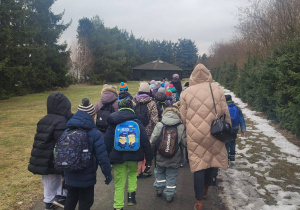 Uczniowie idą chodnikiem do Ośrodka Edukacji Technicznej "Pinokio".