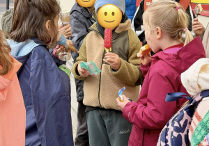 Uczniowie jedzą lody.