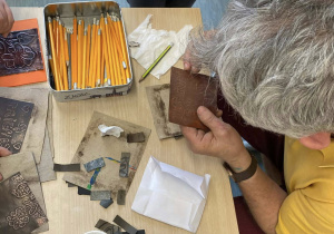 Pan Jacek ogląda prace dzieci i wprowadza małe poprawki.