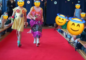 Dziewczynki prezentują swoje kolorowe kreacje na wybiegu.