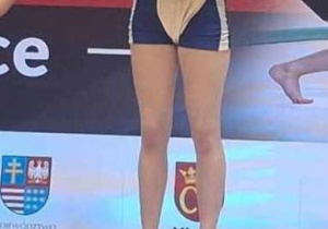 Zawodniczka stoi na podium podczas dekoracji medalami.
