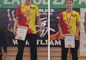 Adam i Karol stoją na podium podczas dekoracji medalami.