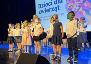 Uczniowie stoją na scenie podczas występu z okazji gali na zakończenie projektu.